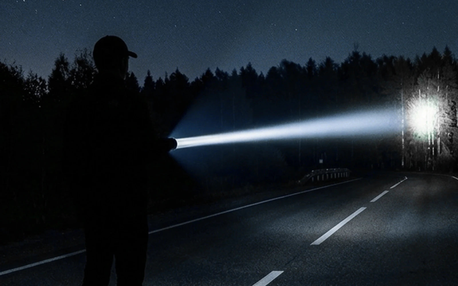 Focused flashlight beam aimed toward a distant trail marker